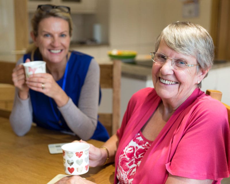 Caregiver and client having coffee together