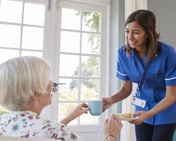 Caregiver serves client some tea