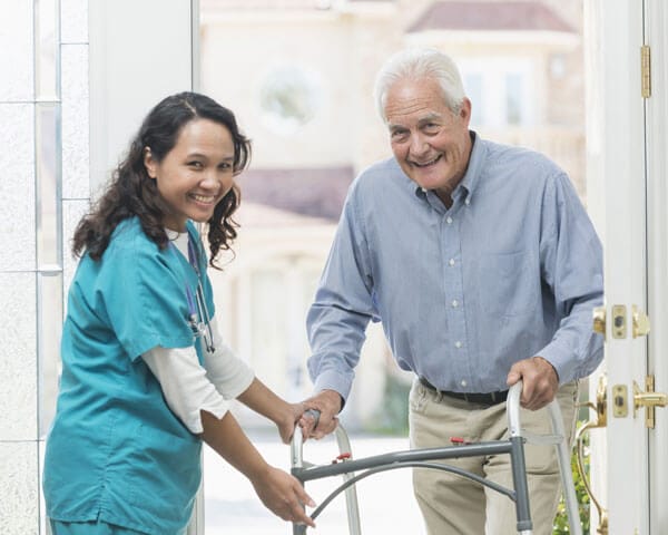 Caregiver helping senior man with walker
