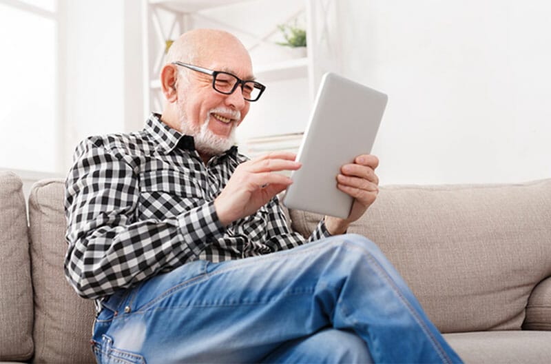 happy senior man on tablet