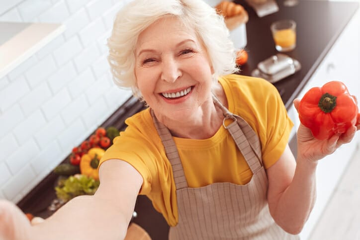 happy senior lady holding pepper